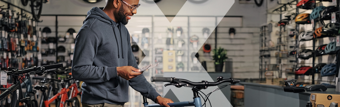 A person looking for a new affordable bike in a bike shop, so they can cut down their cost of commuting to work