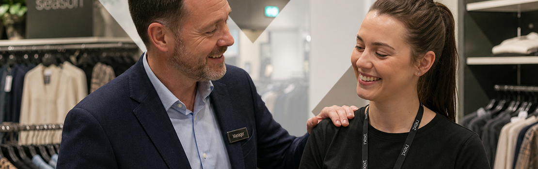 A retail manager showing an employee recognition in a retail workplace setting