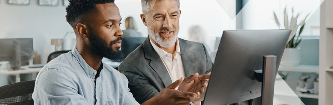An employee and an employer looking at a new computer together, showing how a home and tech salary sacrifice scheme benefits employees and employers alike