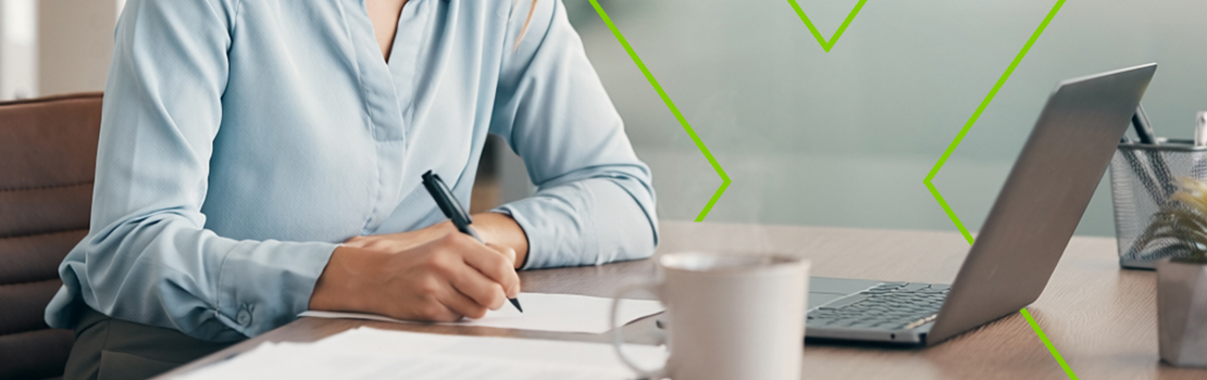 An employee writing at their desk as they fill out a questionnaire about a corporate wellness programme
