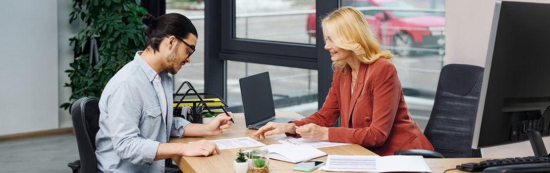 A retail employee and a HR manager filling out forms related to onboarding, the third stage in the employee lifecycle
