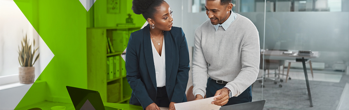 A manager and a HR professional looking at a document as they consider a corporate wellness programme