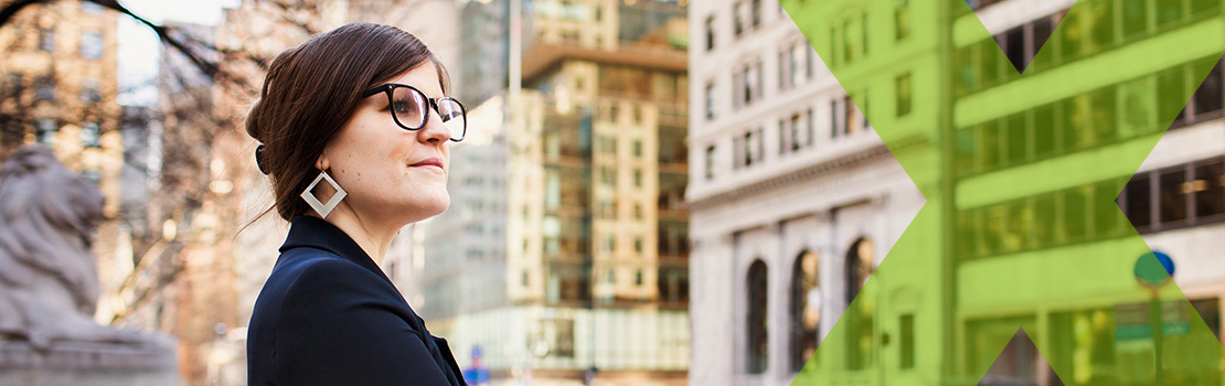 An employee looking up at a business's city office space, showing attraction which is the first stage of the employee lifecycle