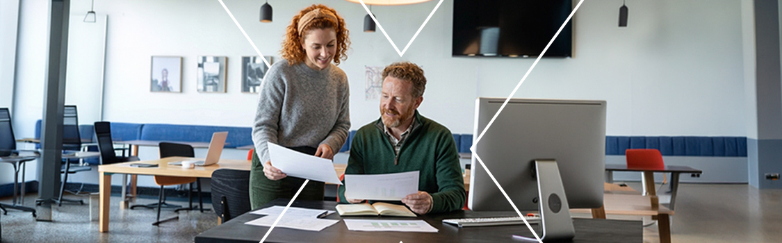 A HR manager explaining how fringe benefits work to an employee in a communal office space