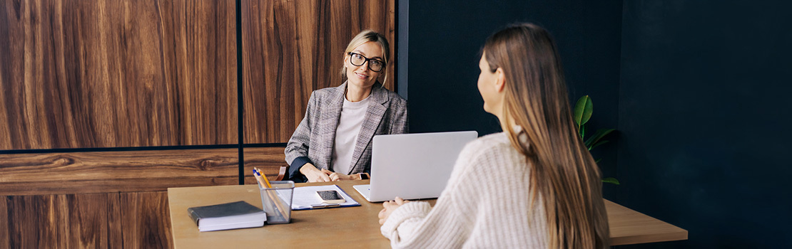 A HR manager giving an employee an exit interview in an office, demonstrating how offboarding is the sixth and final stage of the employee lifecycle